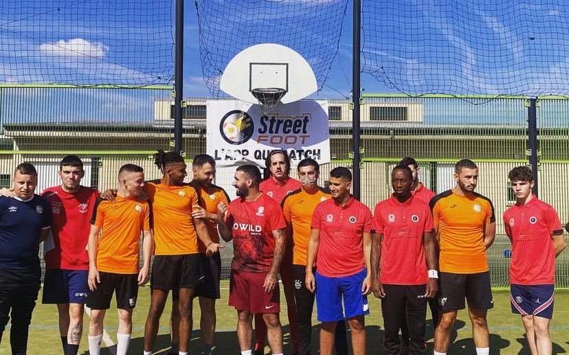 Équipe StreetFoot réunie sous un panier de basket, devant la banderole « L'app qui match ».