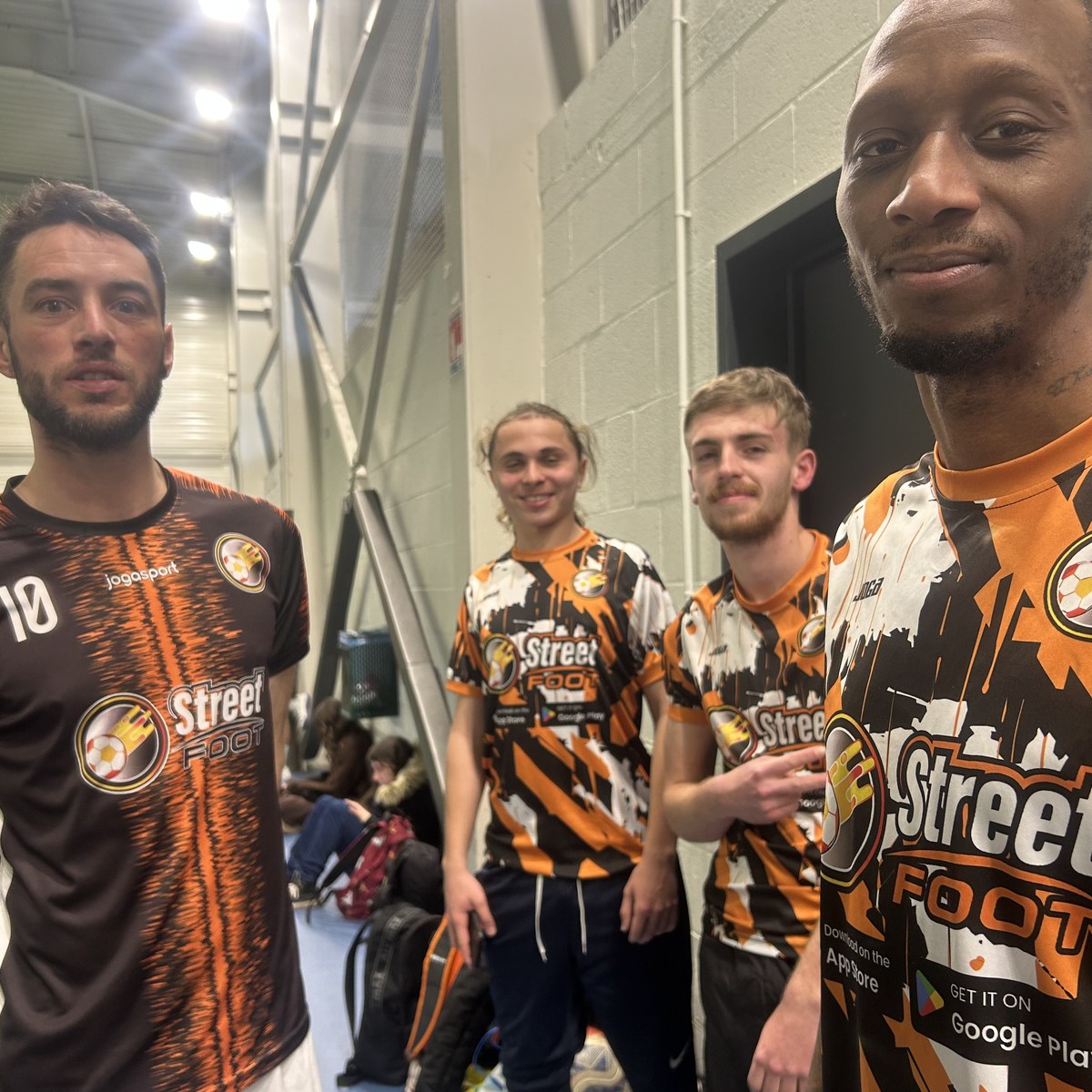 Quatre joueurs StreetFoot en maillots floqués posant après un match.